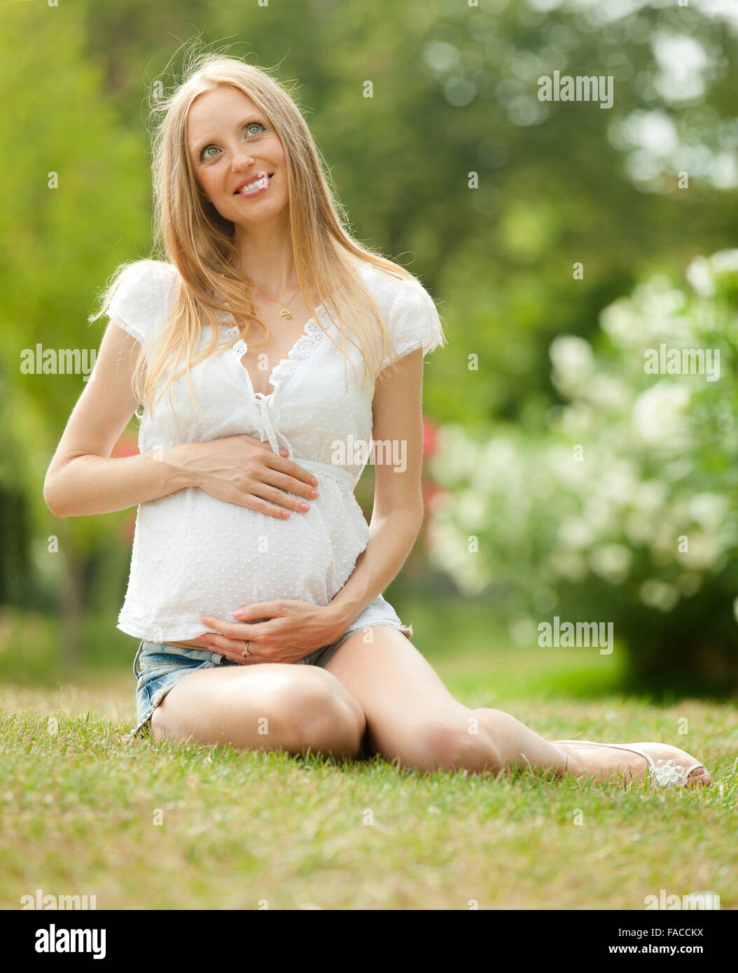 Happy pregnant woman relaxing on grass in summer park Stock Photo - Alamy
