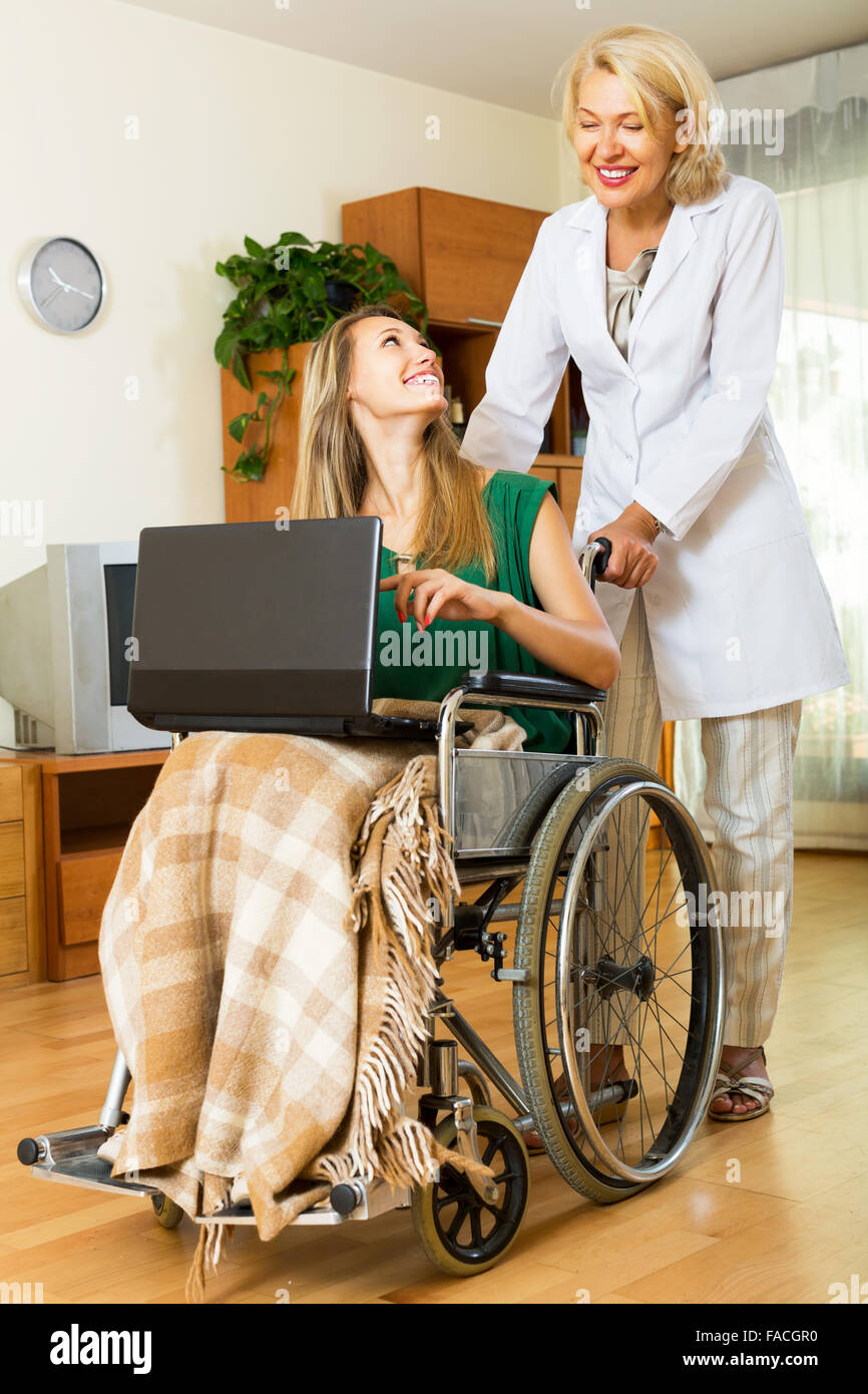 Happy woman in wheelchair working on laptop indoor Stock Photo - Alamy