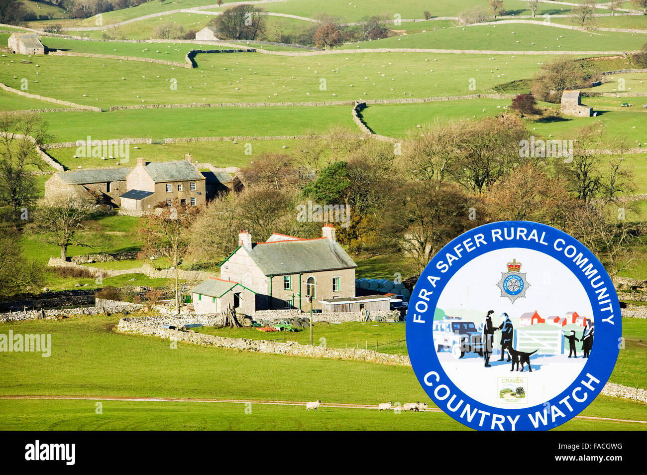 Farm houses below Wild Boar Fell in the north Pennines UK with a police country watch sign. Stock Photo