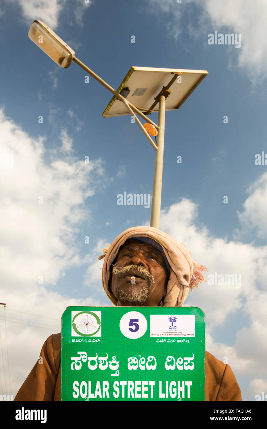 An old man underneath a solar street light in Karataka State near Mysore, India. Stock Photo