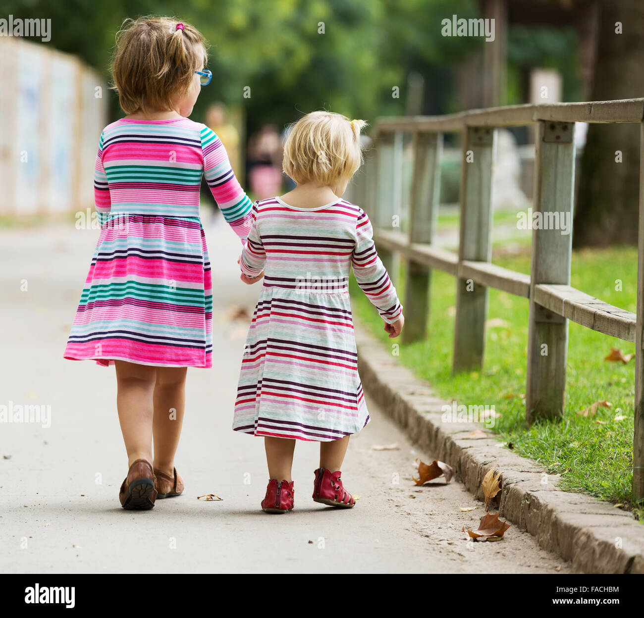 Rear view of little girls at street in summer Stock Photo - Alamy