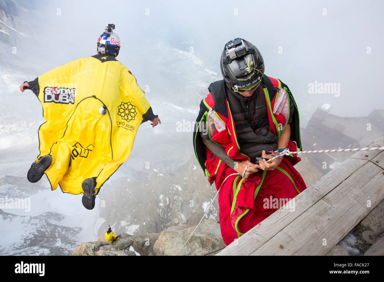 Base jumpers wearing wing suites prepare to jump from the Aiguille Du midi above Chamonix, France. Stock Photo