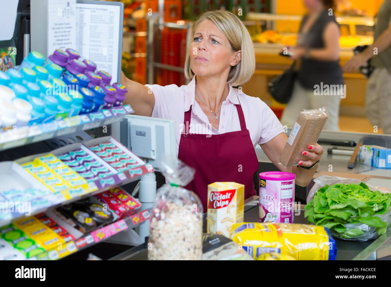 Stressed cashier at the supermarket Stock Photo
