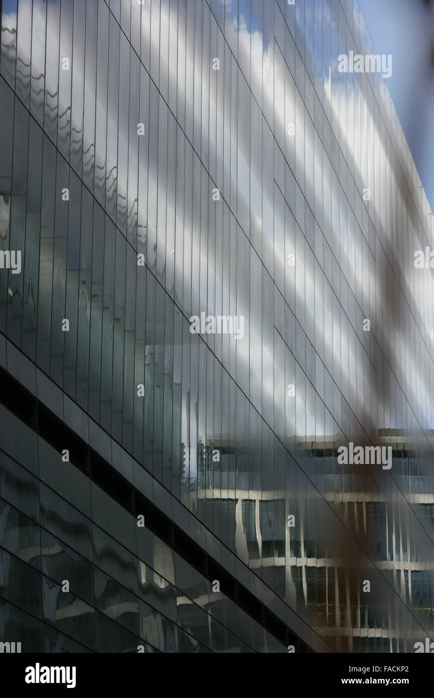 Glass clad building reflecting clouds with light Stock Photo - Alamy