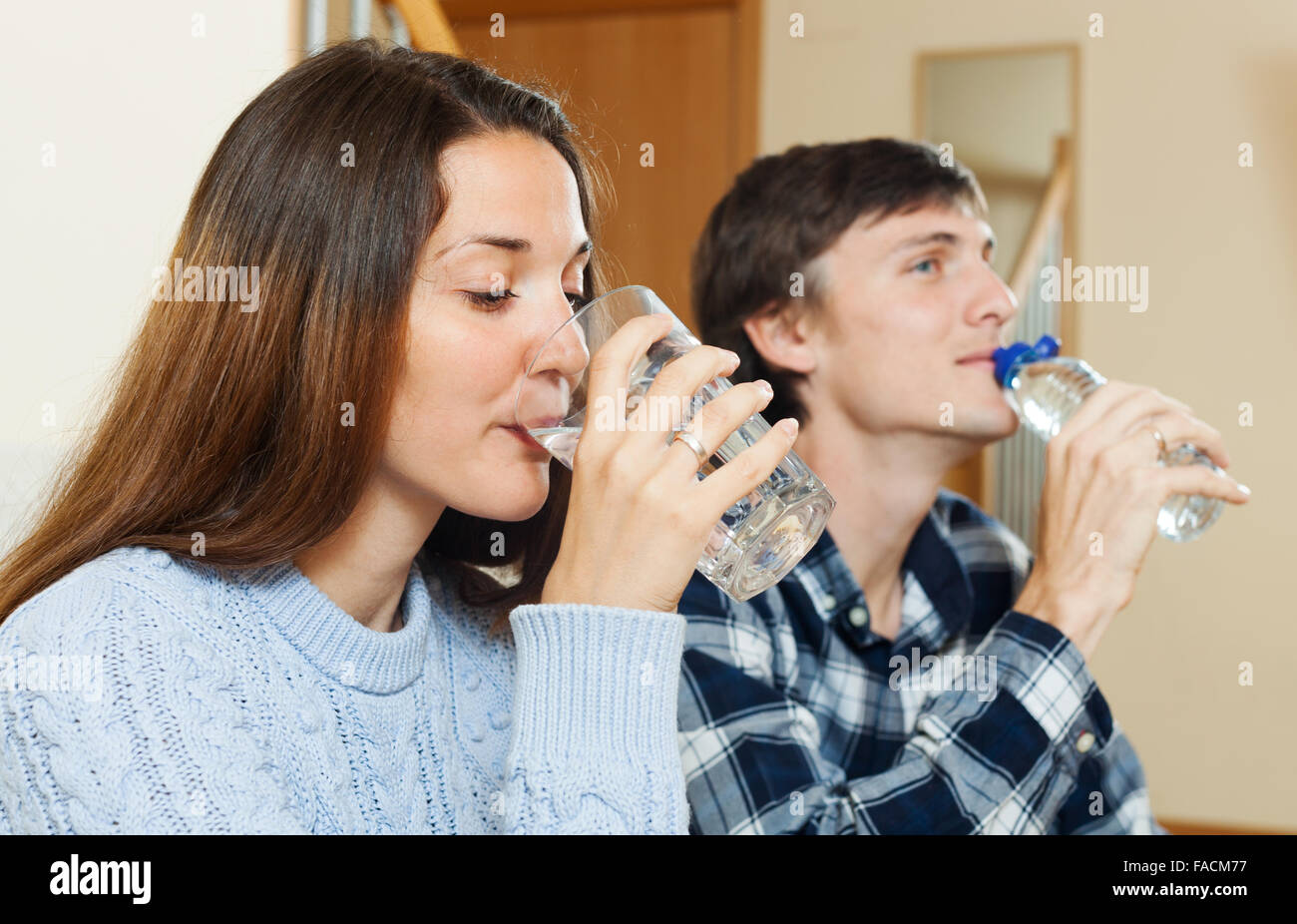 Man and woman drinking clean water at home Stock Photo Alamy