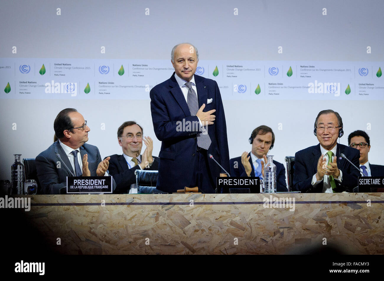 French Foreign Minister Laurent Fabius acknowledges applause after successfully steering a global agreement on greenhouse gas emissions at the COP21, United Nations Climate Change Conference December 12, 2015 in Le Bourget, France. United Nations Secretary General Ban ki-Moon and French President Francois Hollande applaud. Stock Photo