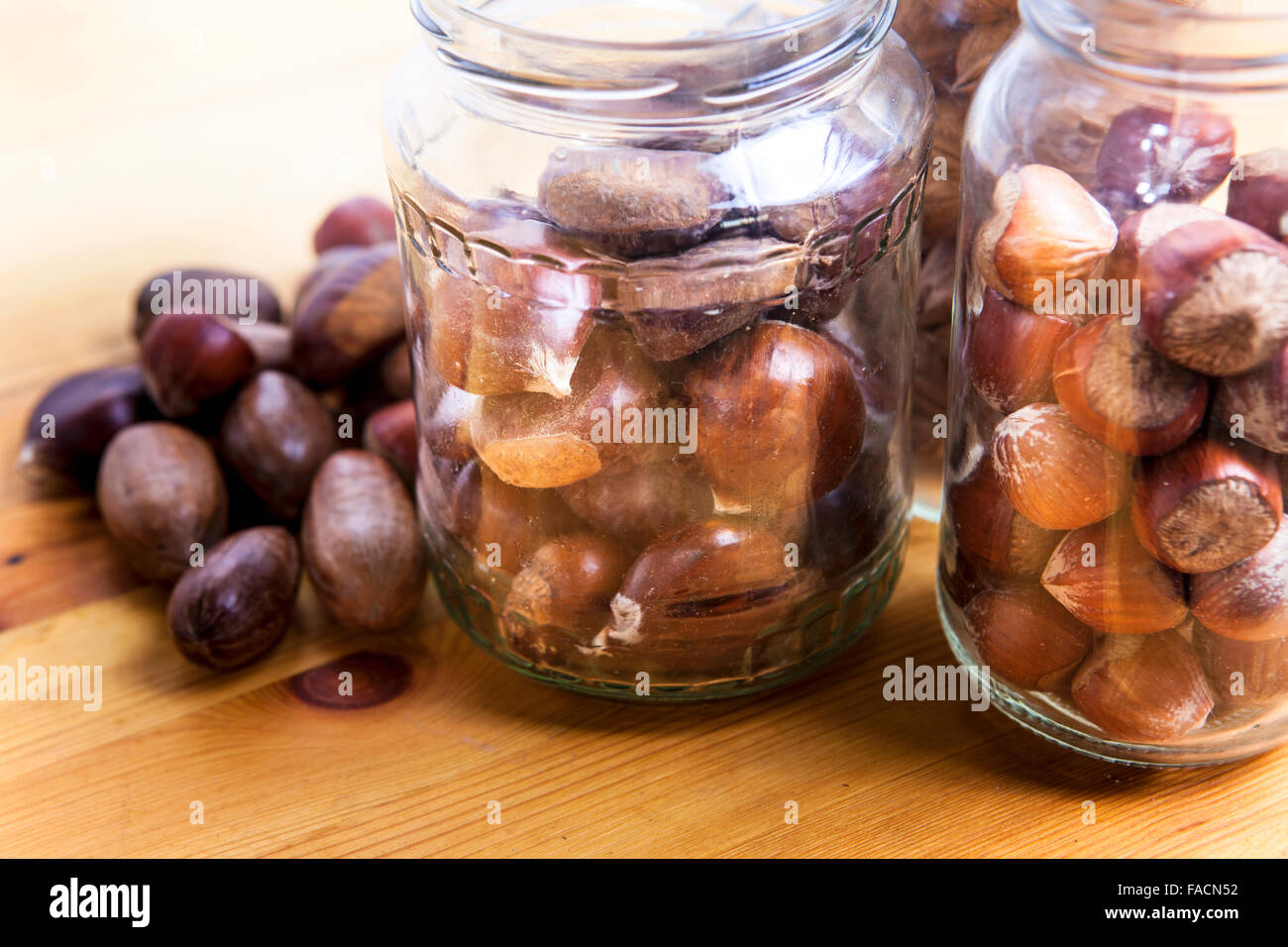 Nuts on glass jars over wooden surface. Isolated over white background Stock Photo