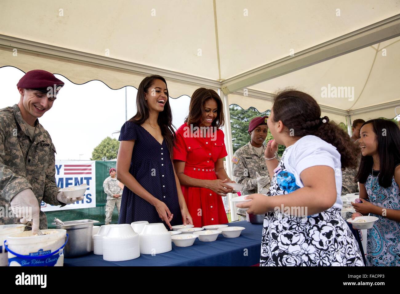US First Lady Michelle Obama and her daughter Malia help serve ice cream to military families at U.S. Army Garrison Vicenza June 19, 2015 in Vicenza, Italy. Stock Photo