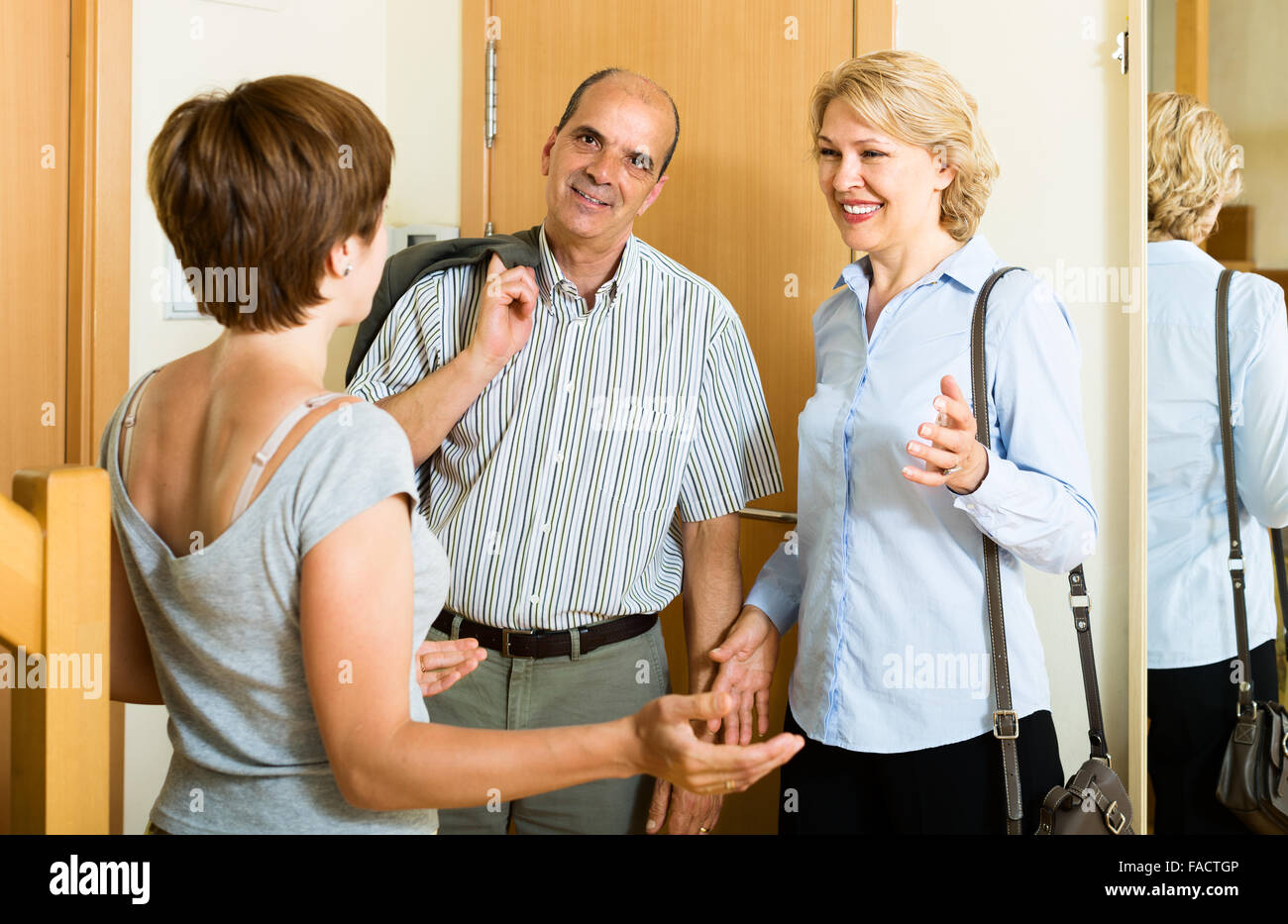 Happy Aged Family Couple Visiting Adult Daughter At Home Stock Photo happy-aged-family-couple-visiting-adult-daughter-at-home-stock-photo