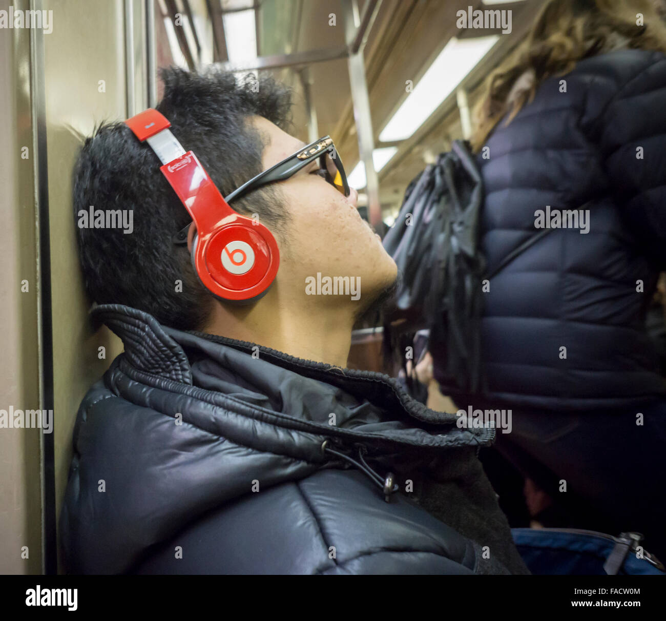 A music listener wears his Beats by Dr. Dre over the ear headphones during a subway ride in New York on Saturday, December 19, 2015. (© Richard B. Levine) Stock Photo
