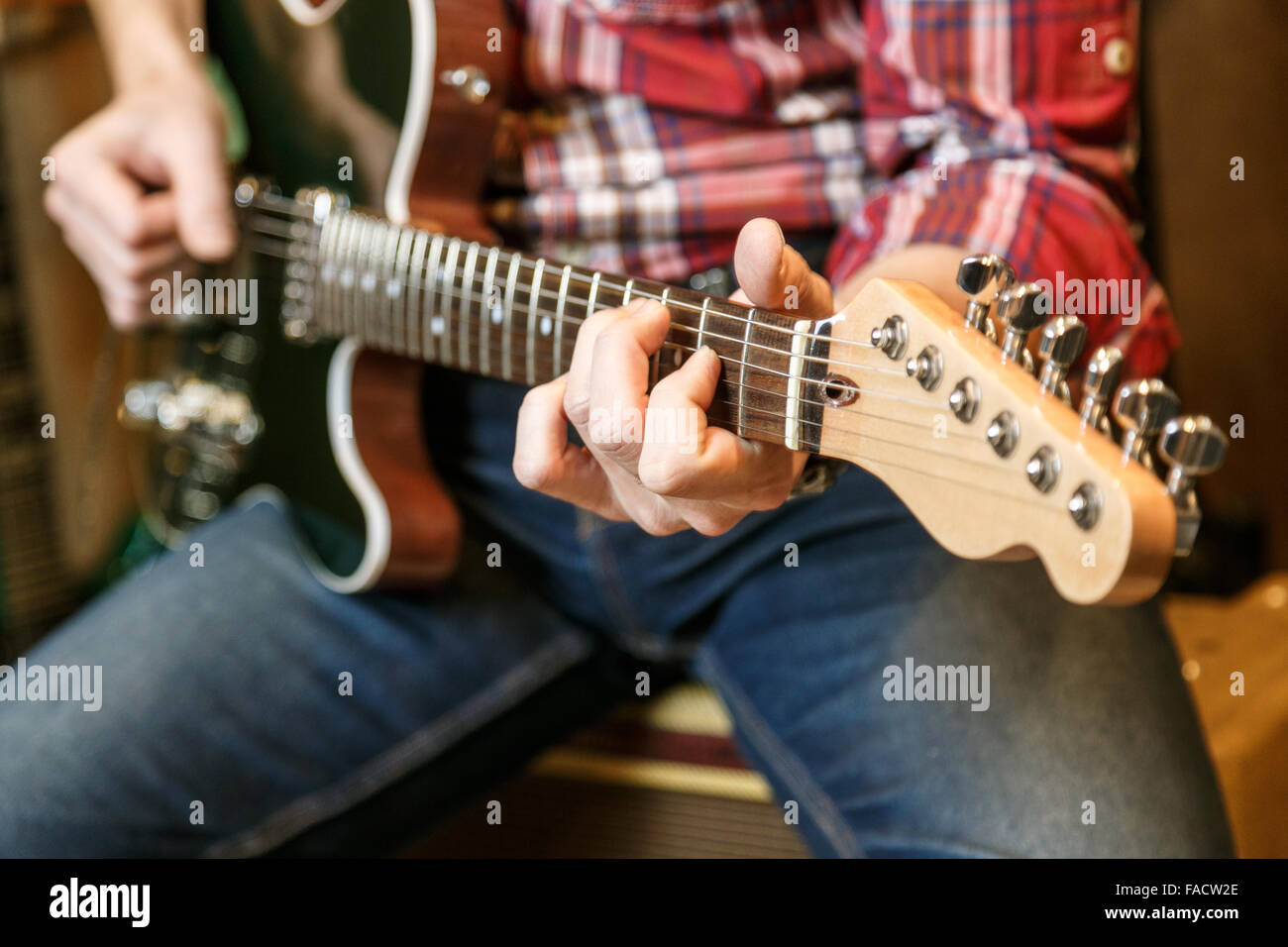 Close up view of man's hands playing electric guitar. Stock Photo