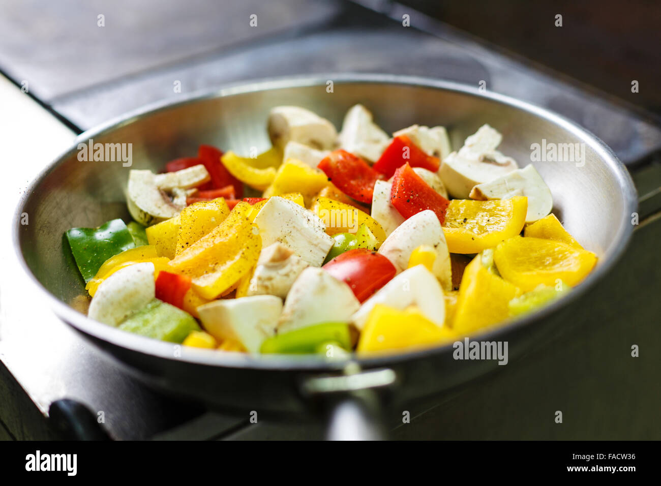 Pan with fresh pepper with mushrooms ready to be cooked on a kitchen stove Stock Photo