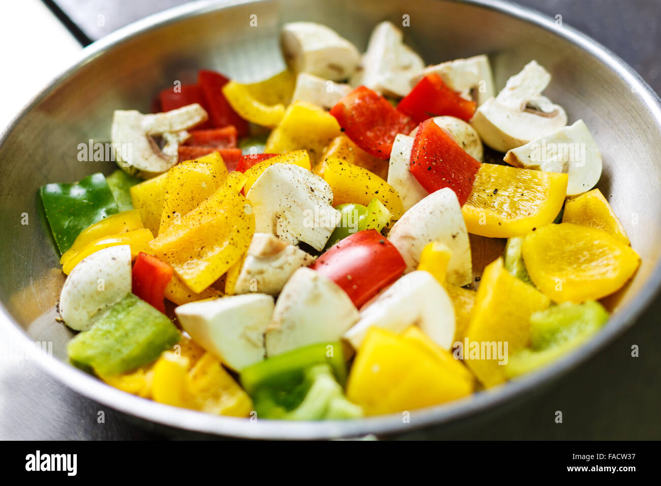 Pan with fresh pepper with mushrooms ready to be cooked on a kitchen stove Stock Photo