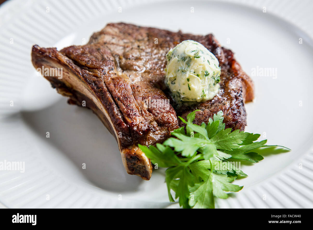 Juicy veal rib steak with green oil Stock Photo