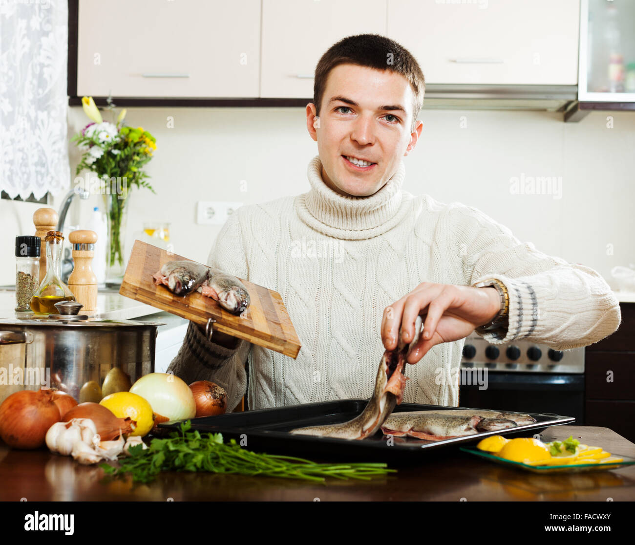 man putting freshwater fish into sheet pan at kitchen Stock Photo - Alamy