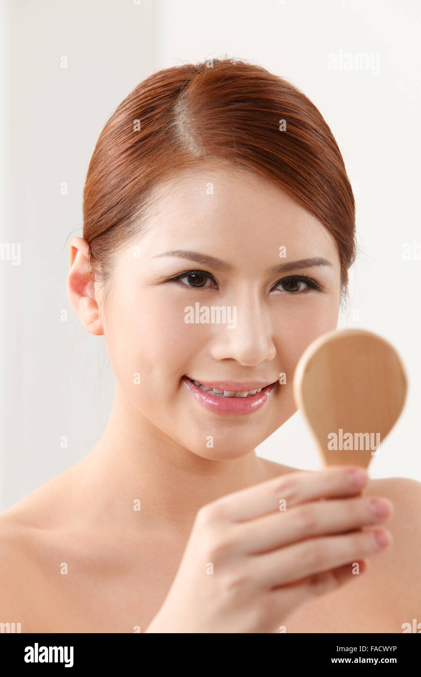 Young woman holding mirror on the