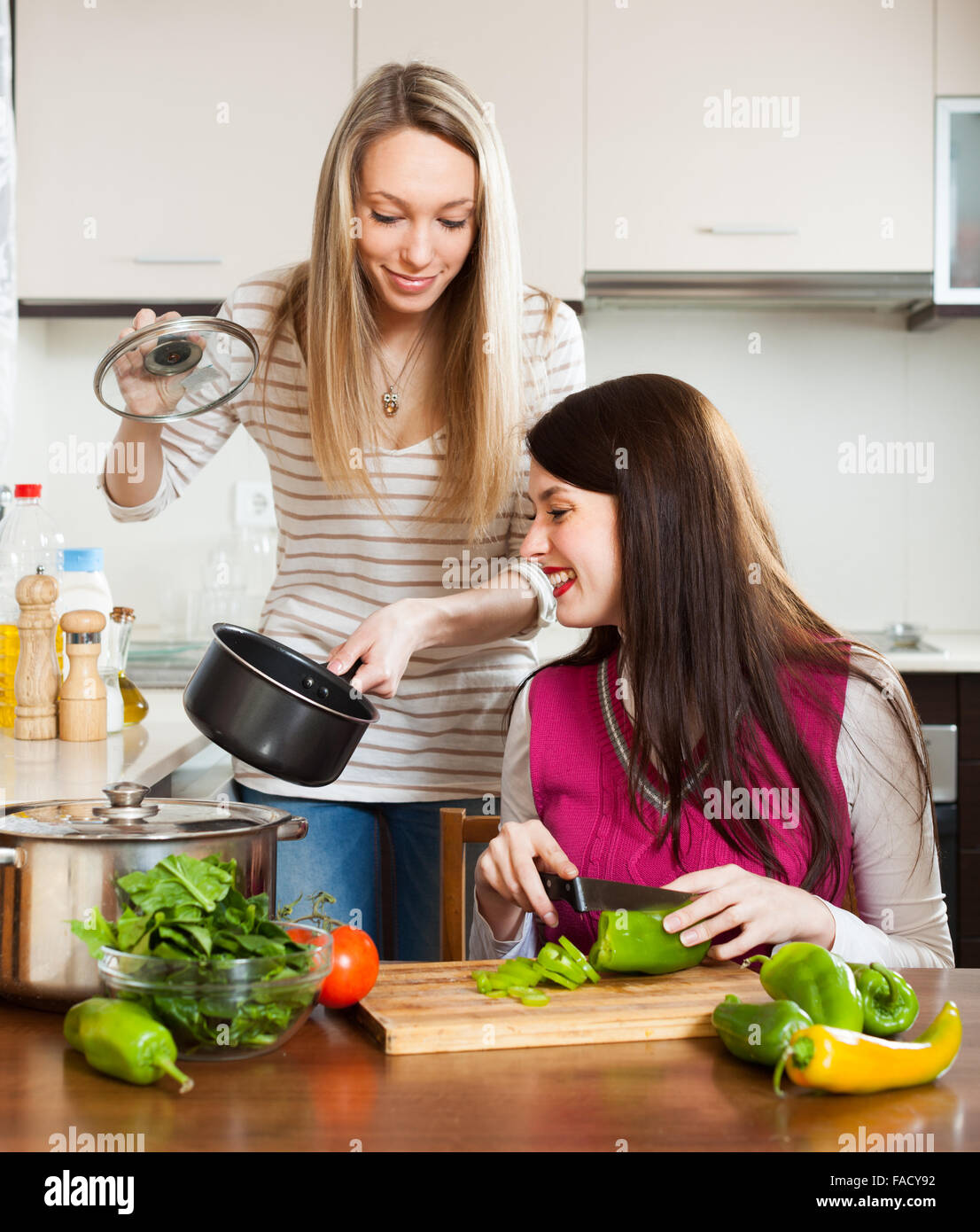 ordinary smiling girls cooking in kitchen at home Stock Photo Alamy