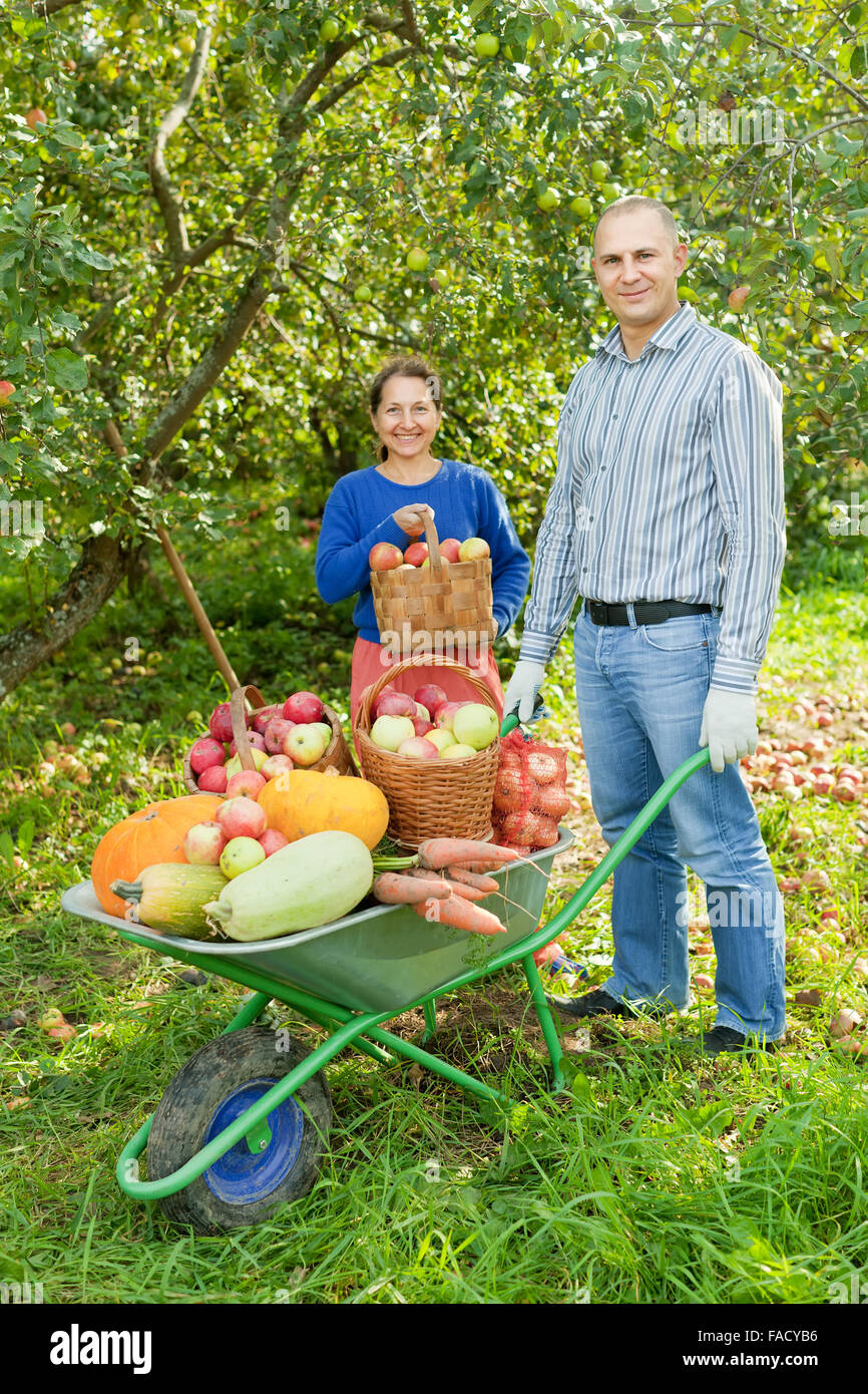 Man and woman with crop of vegetables in garden Stock Photo - Alamy