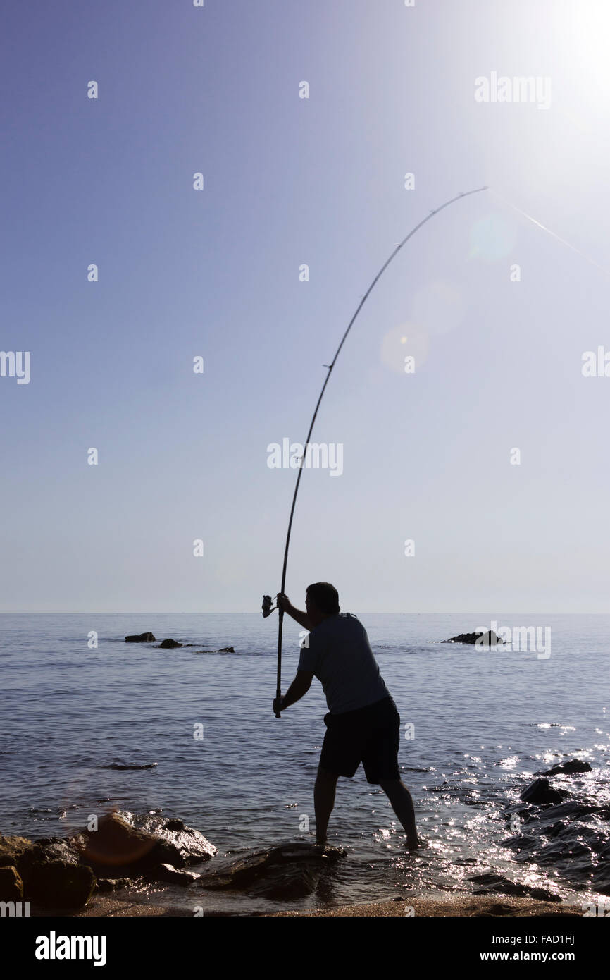 Silhouette of man sea fishing at sunset Stock Photo - Alamy