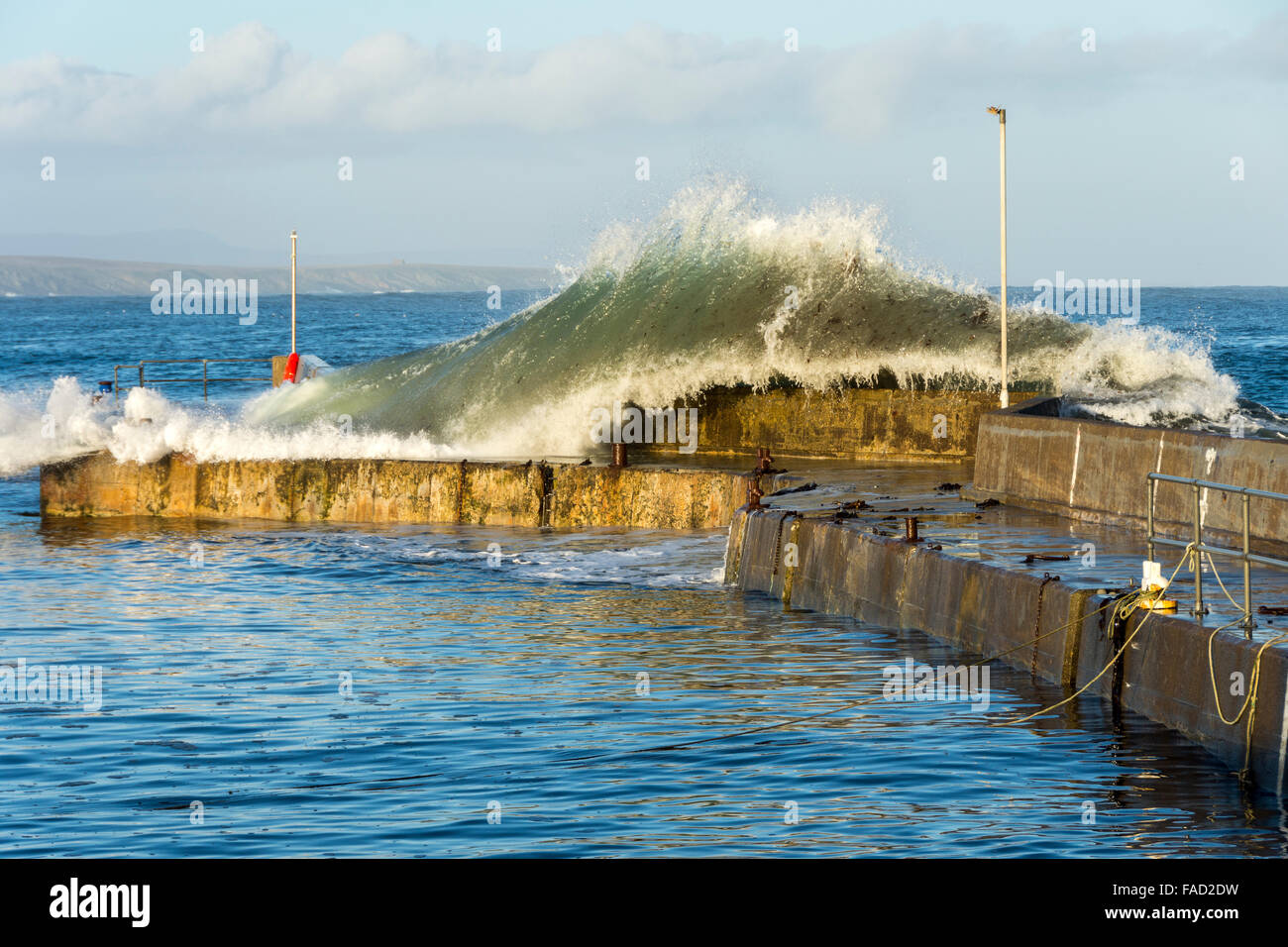 John o'Groats Harbour, Caithness, Scotland UK. 27th December 2015.  Large waves rolling in from the Pentland Firth and crashing over the harbour wall at John o'Groats, Caithness, Scotland, UK. Stock Photo