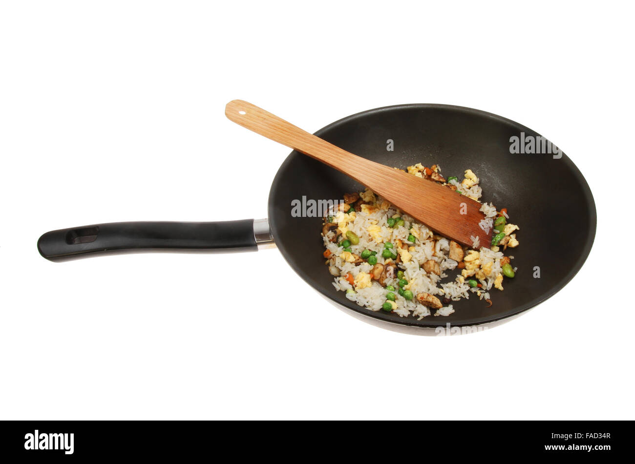 Fried rice with a wooden spatula in a wok isolated against white Stock Photo