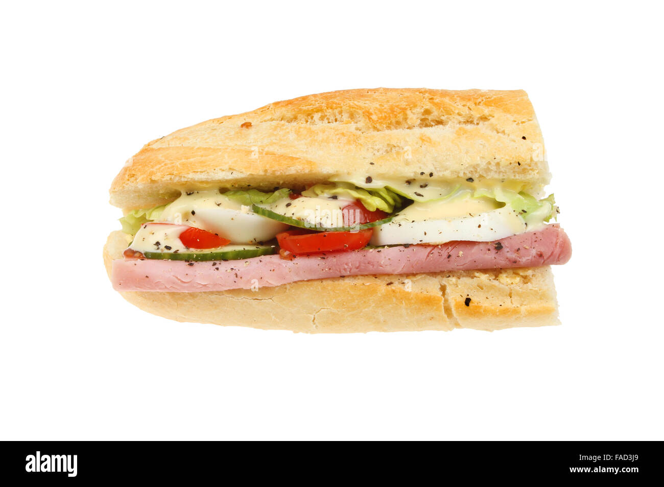 Ham, salad and egg baguette with mayonnaise isolated against white