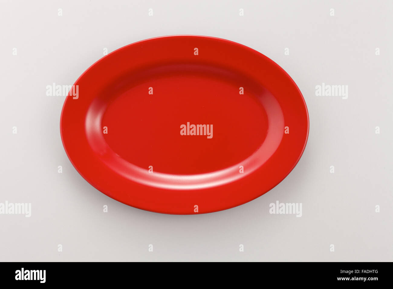 Empty red plate on the white background Stock Photo - Alamy