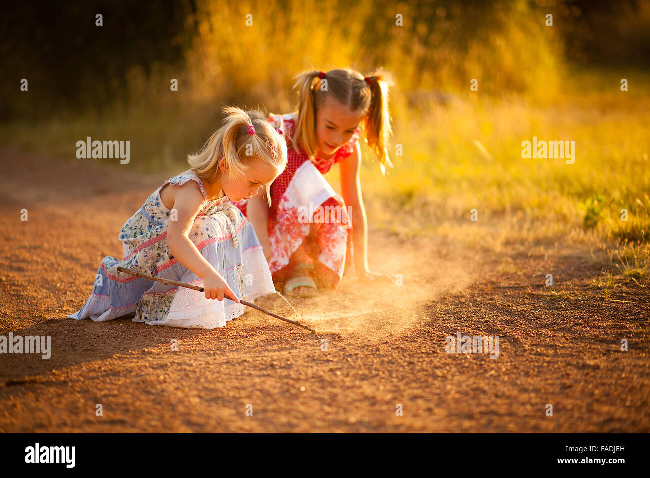Two sisters playing in the dirt Stock Photo