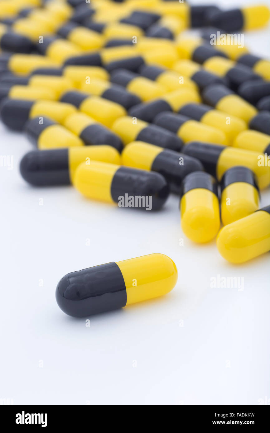 Close Up Of Yellow And Black Pills Capsule Form Made Of Gelatin