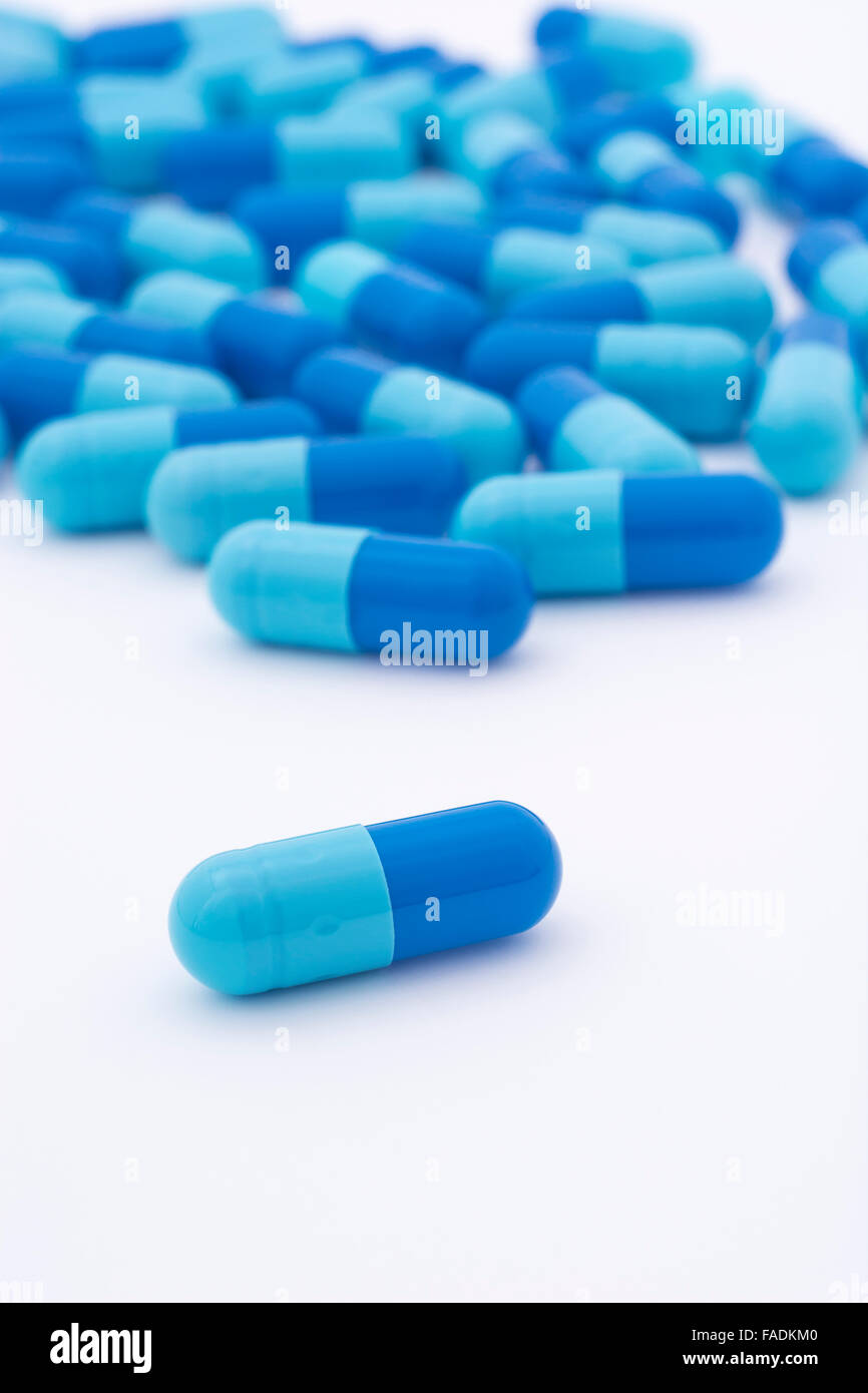 Closeup of blue pills capsule form made of gelatin. Big Pharma
