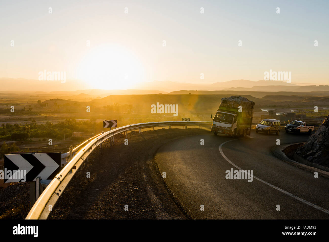 Loaded truck on curvy road in Dades Valley at sunset, Ouarzazate, Morocco Stock Photo