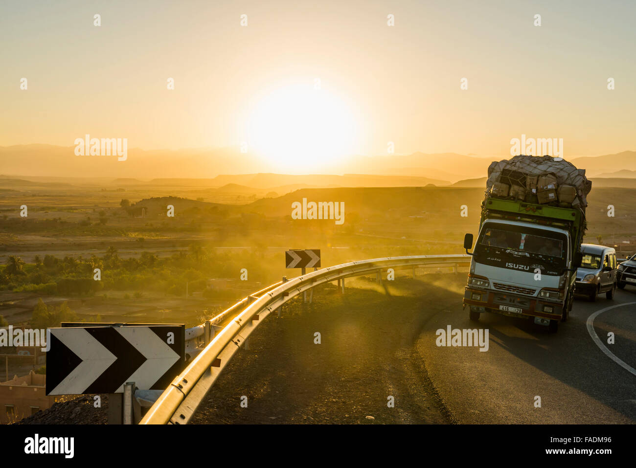 Loaded truck on curvy road in Dades Valley at sunset, Ouarzazate, Morocco Stock Photo