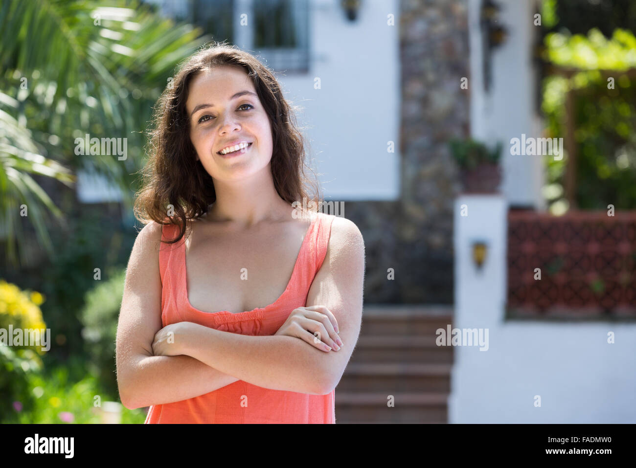 Smiling young woman posing in yard of her residence Stock Photo - Alamy