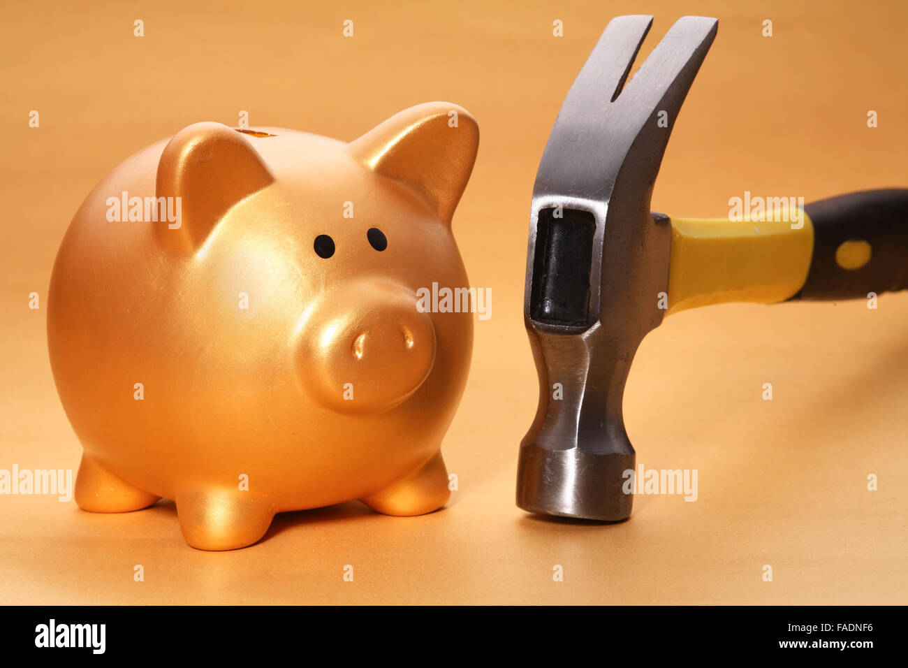 Gold piggy bank and hammer on desk Stock Photo - Alamy