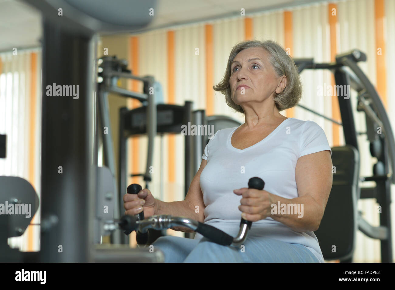 Senior woman exercising in a gym Stock Photo - Alamy