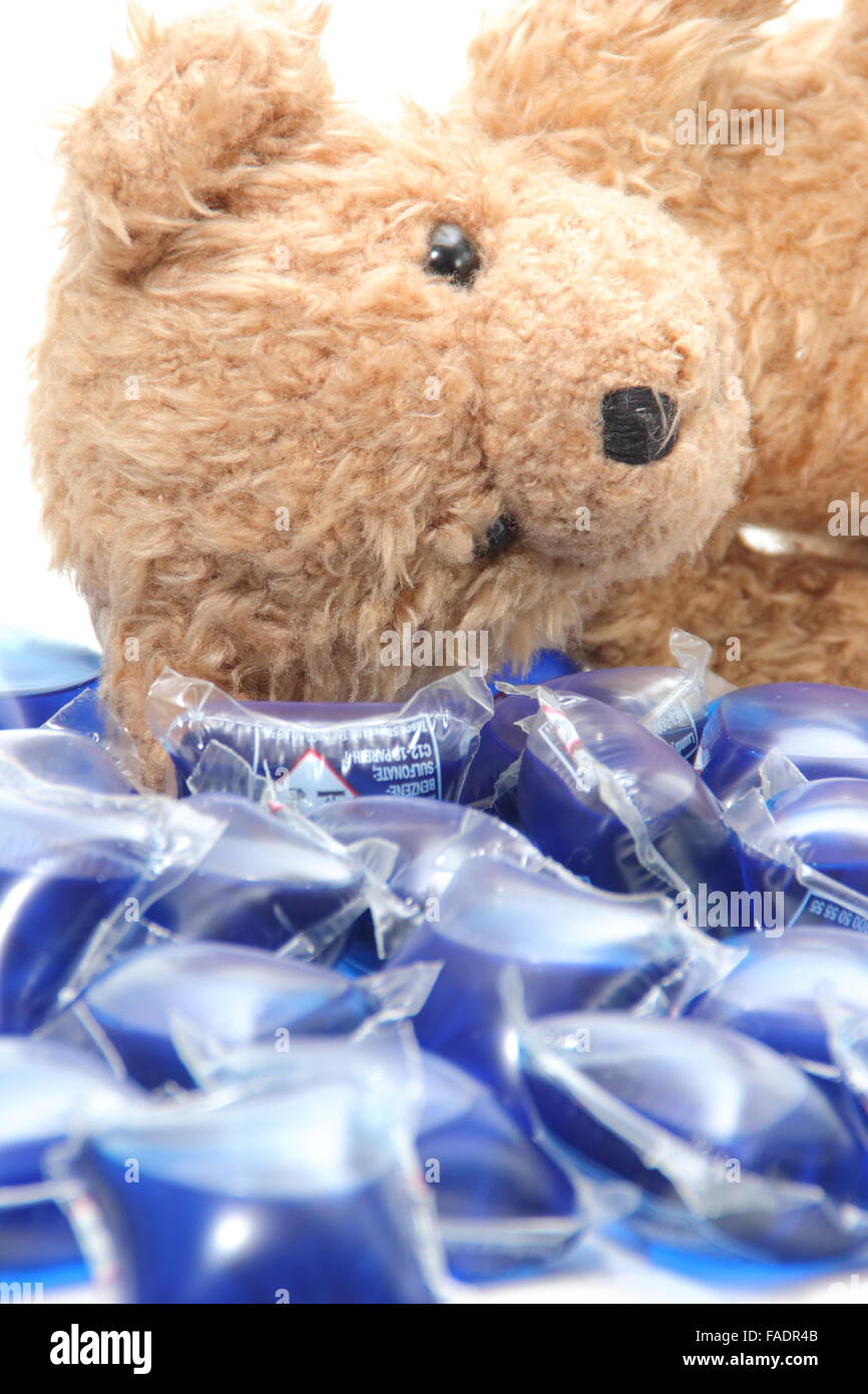 Liquid laundry detergent capsules surround a child's teddy bear UK