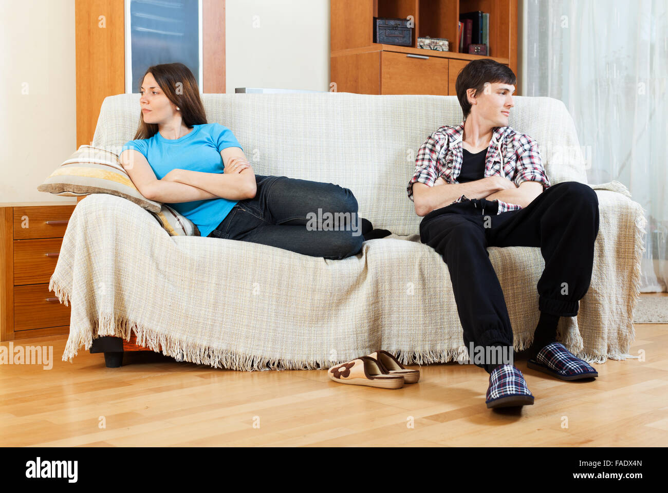 Sad young couple after conflict on sofa at home Stock Photo - Alamy