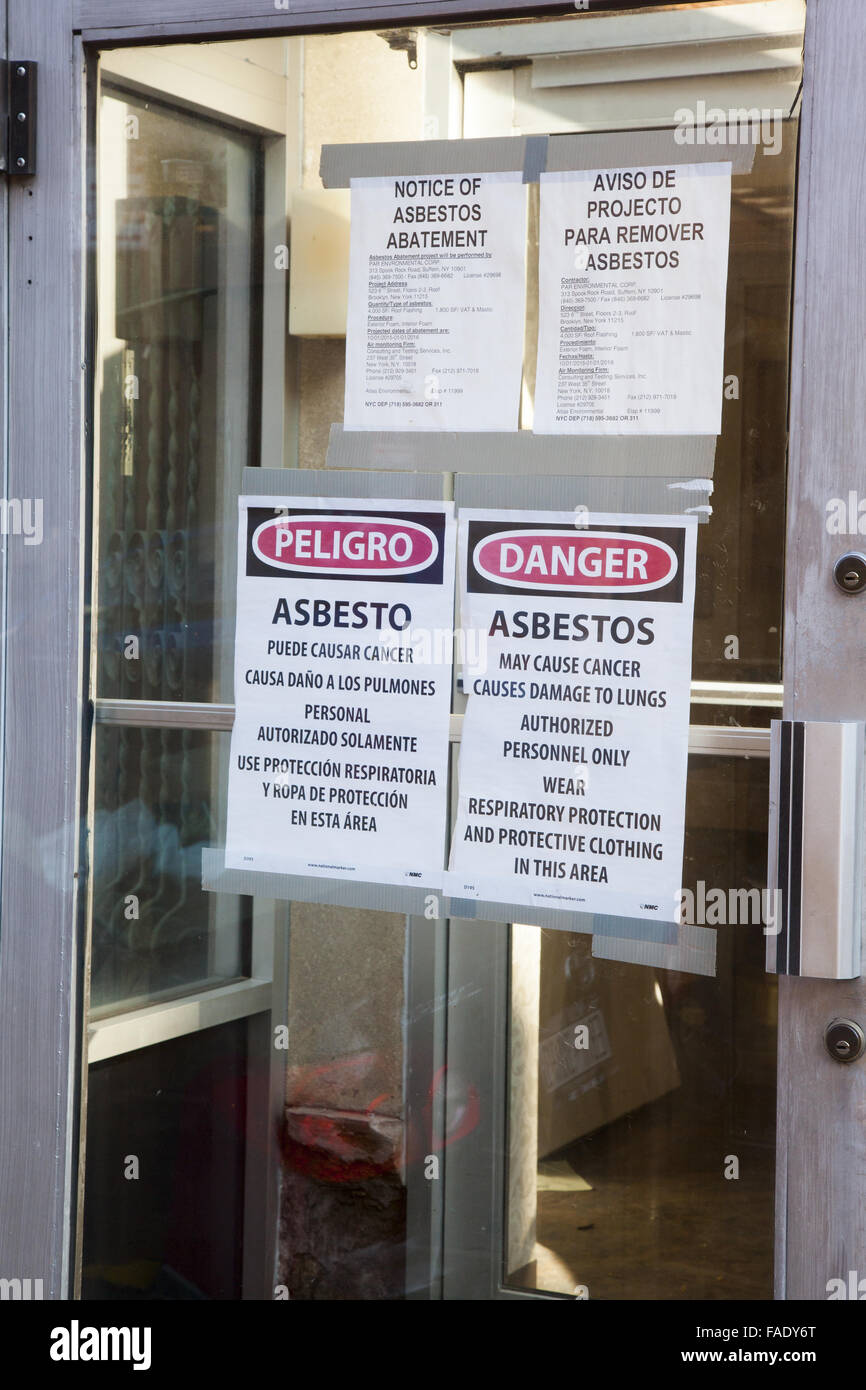 Posted warning signs of Asbestos in a building scheduled to be gutted for renovation. Brooklyn, NY. Stock Photo