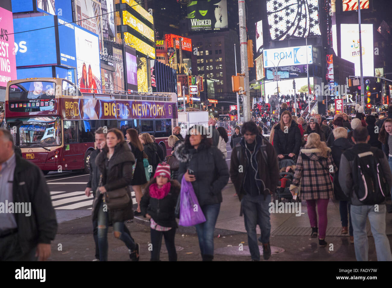 Crowds of people cruise the Times Square neighborhood in the evening during the Christmas season in Manhattan, NYC. Stock Photo