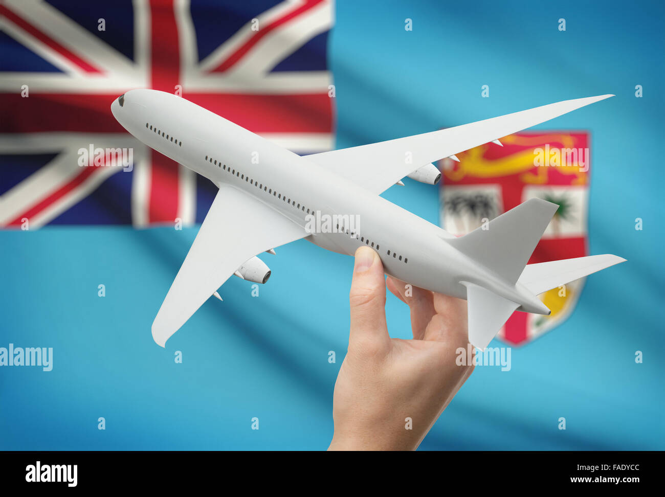 Airplane in hand with national flag on background - Fiji Stock Photo