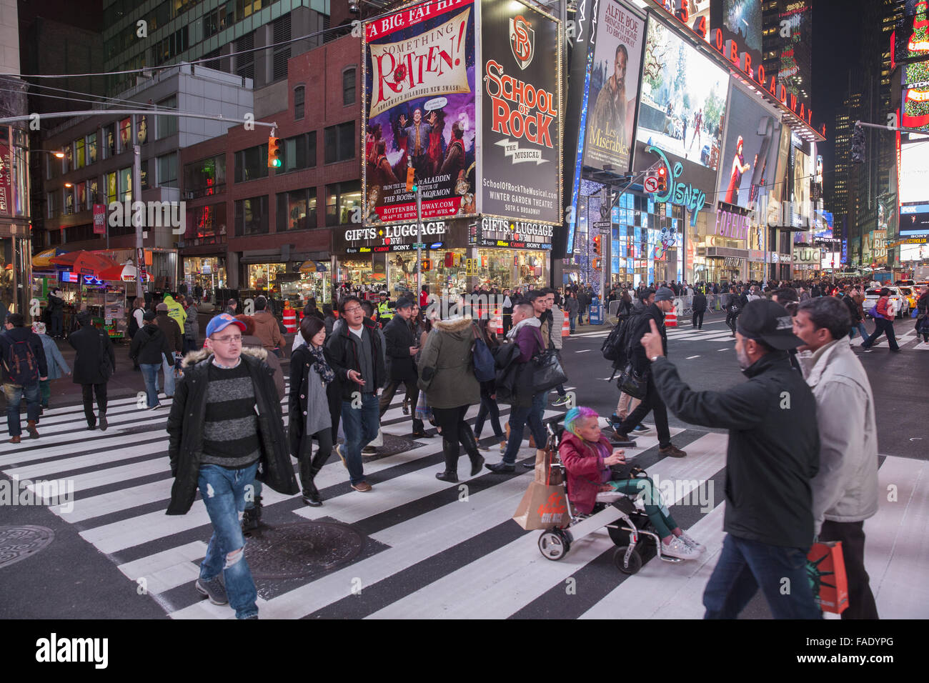 Crowds of people cruise the Times Square neighborhood in the evening during the Christmas season in Manhattan, NYC. Stock Photo