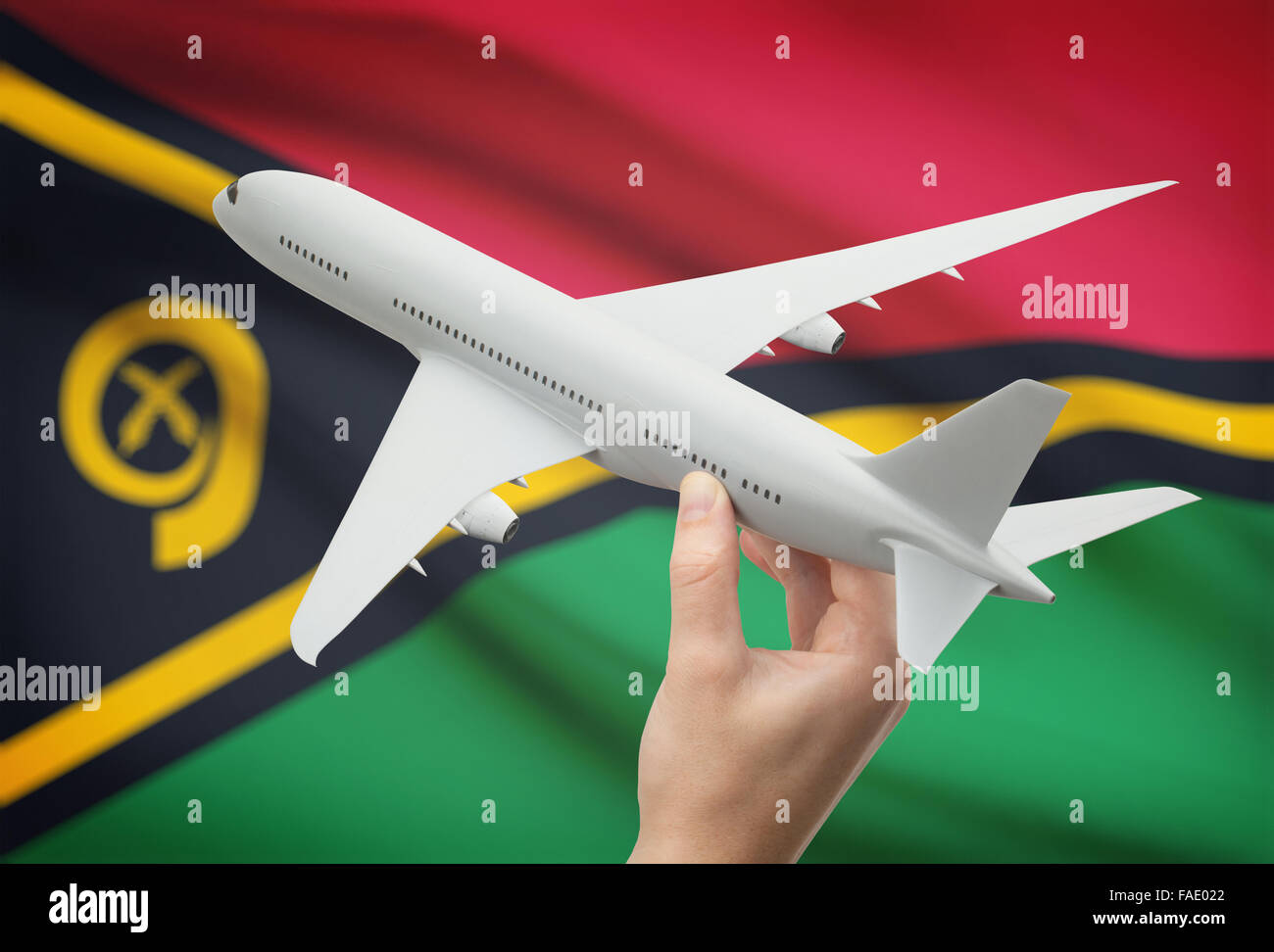 Airplane in hand with national flag on background - Vanuatu Stock Photo
