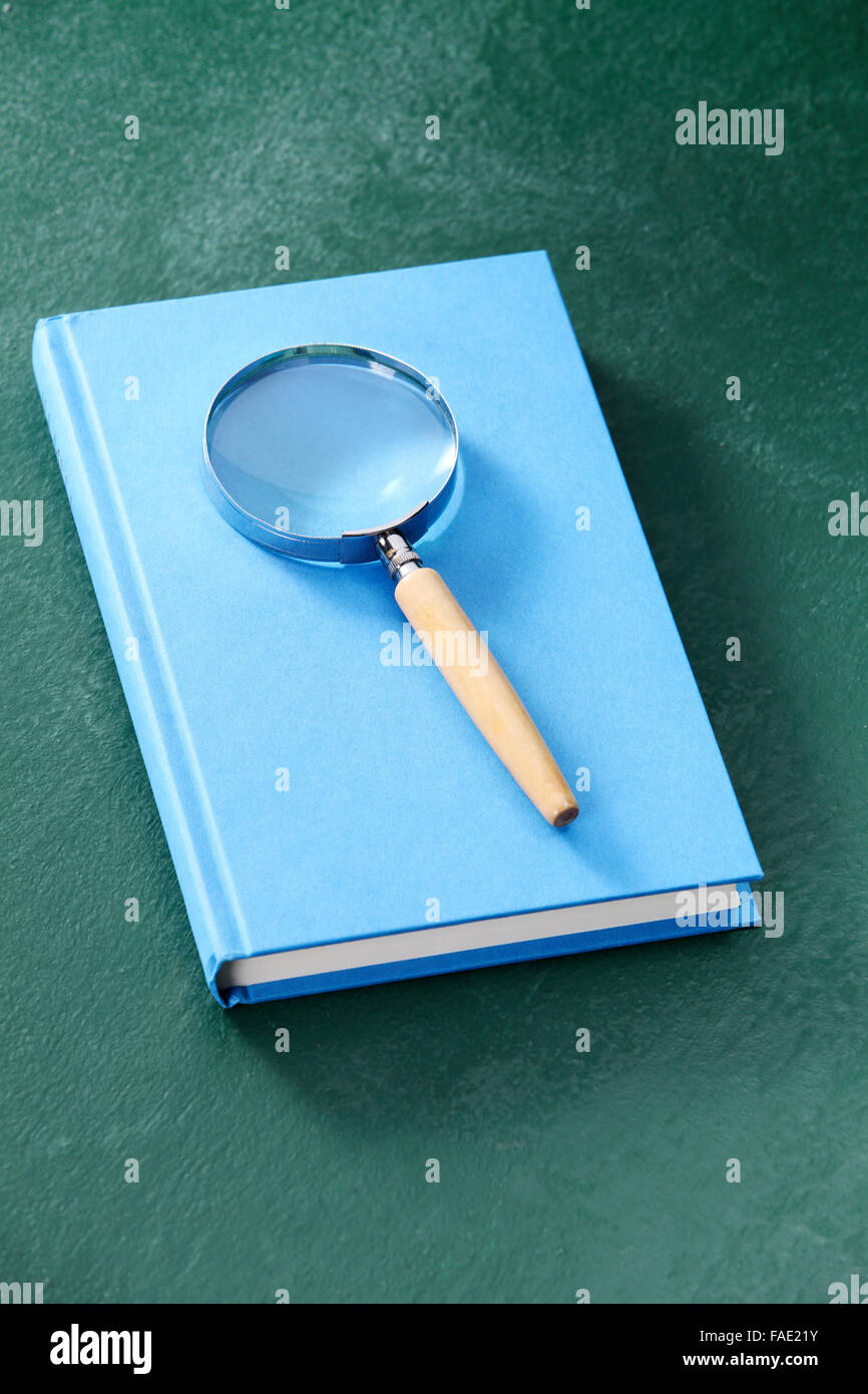 magnifying glass resting on book Stock Photo - Alamy