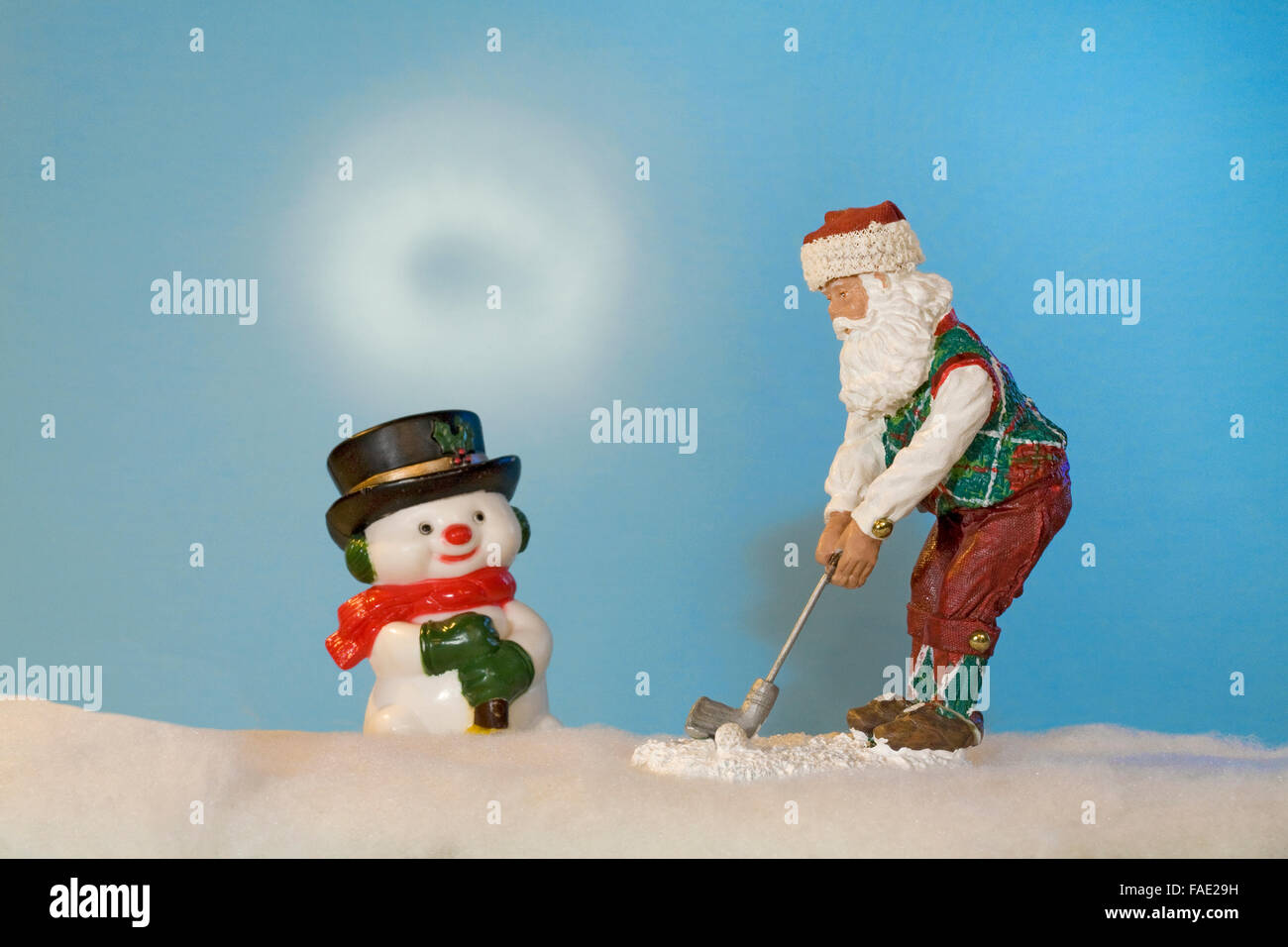 Santa Clause and his snowman friend play golf in a snowfield at the North Pole, just before Christmas. Stock Photo