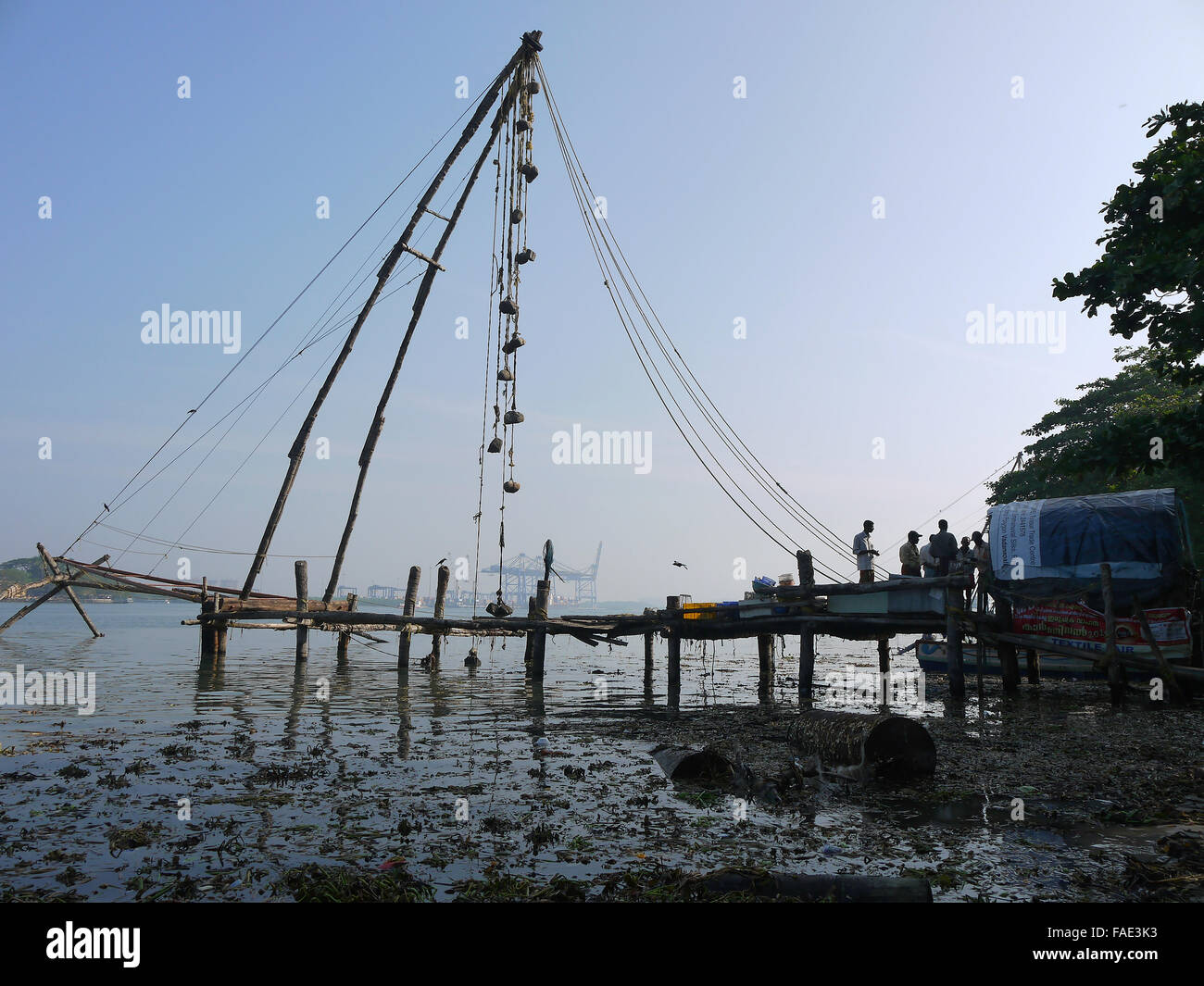 Chinese Fishing Net - This rustic rope and wooden structure stands tall .  Fishermen gather to one side of the net. Kochi India Stock Photo - Alamy