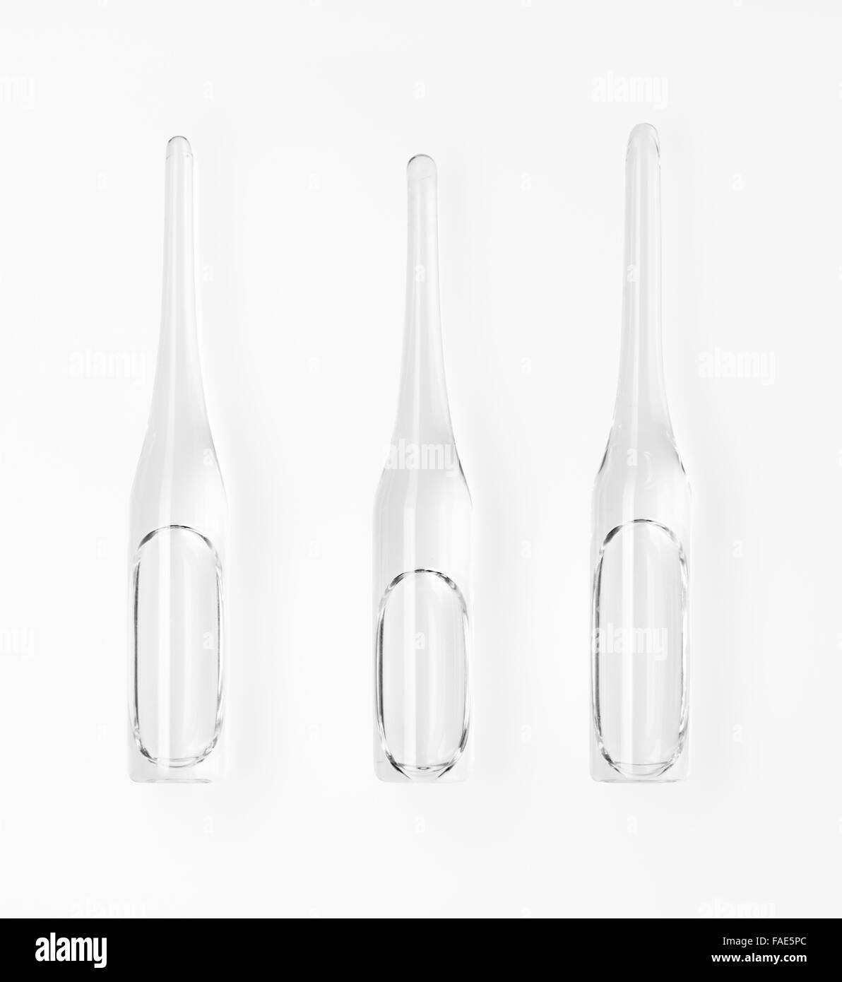Three transparent white glass ampoules with a drug isolated on white