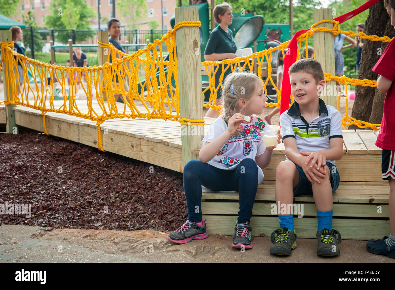 Children sitting together at a playground. Stock Photo