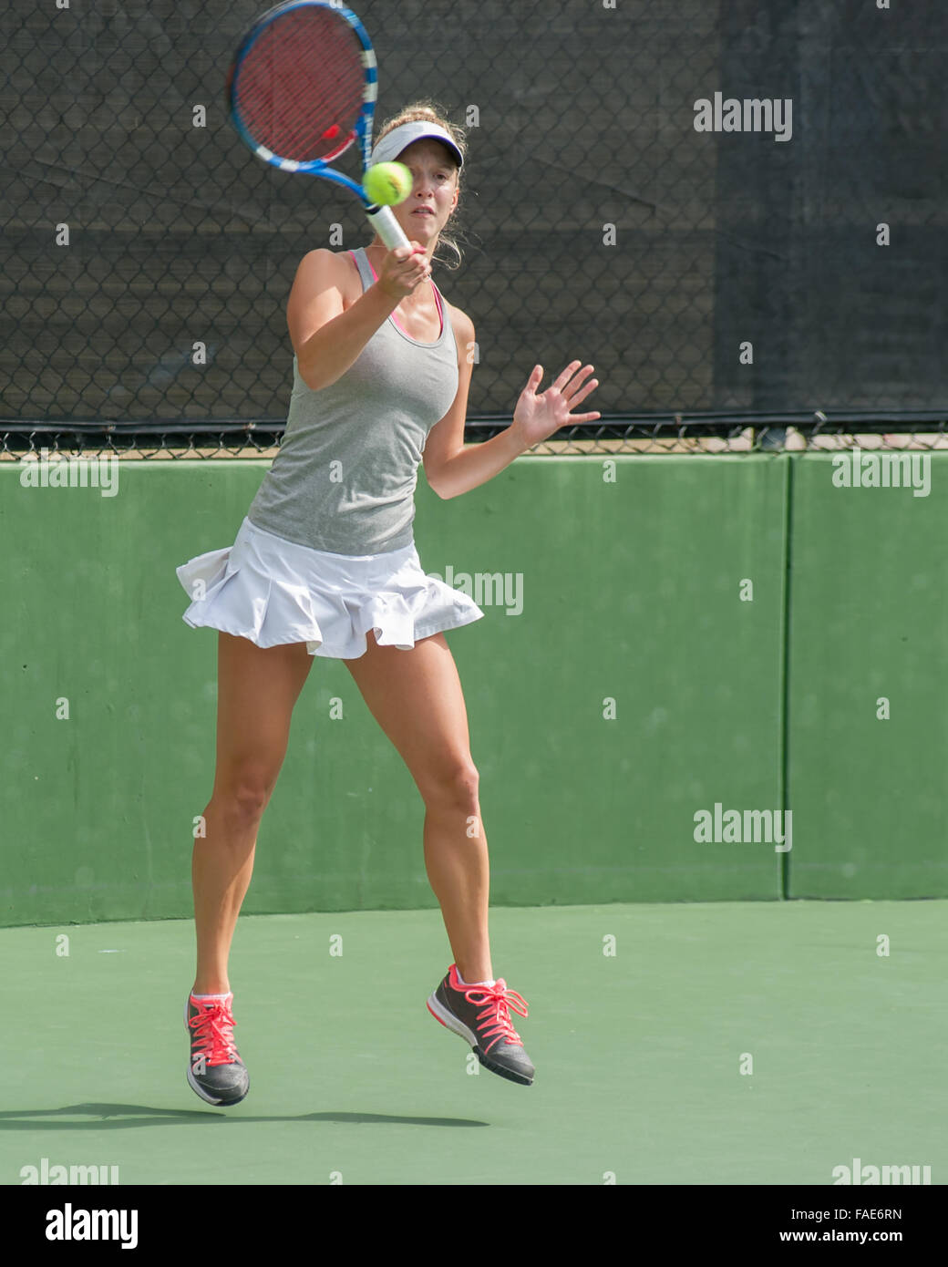 Female tennis player keeping eye on ball as she follows through on forehand. Stock Photo