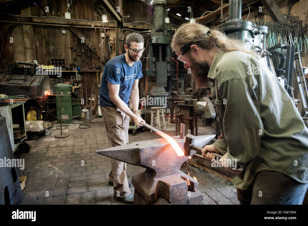 Blacksmith in his Forge with an apprentice Stock Photo