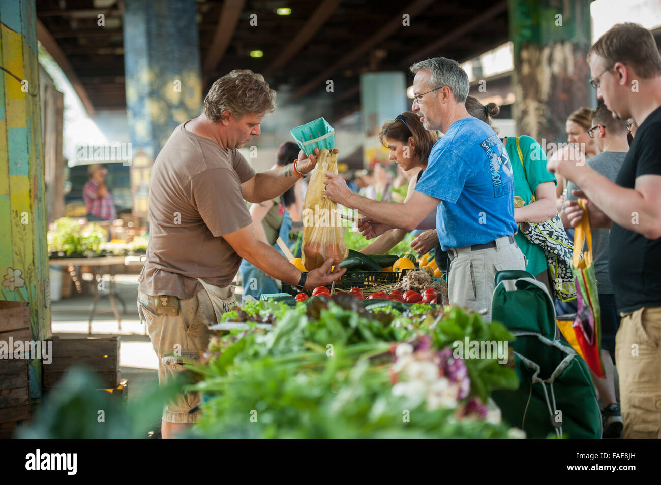 People buying produce at a local farmers market Stock Photo